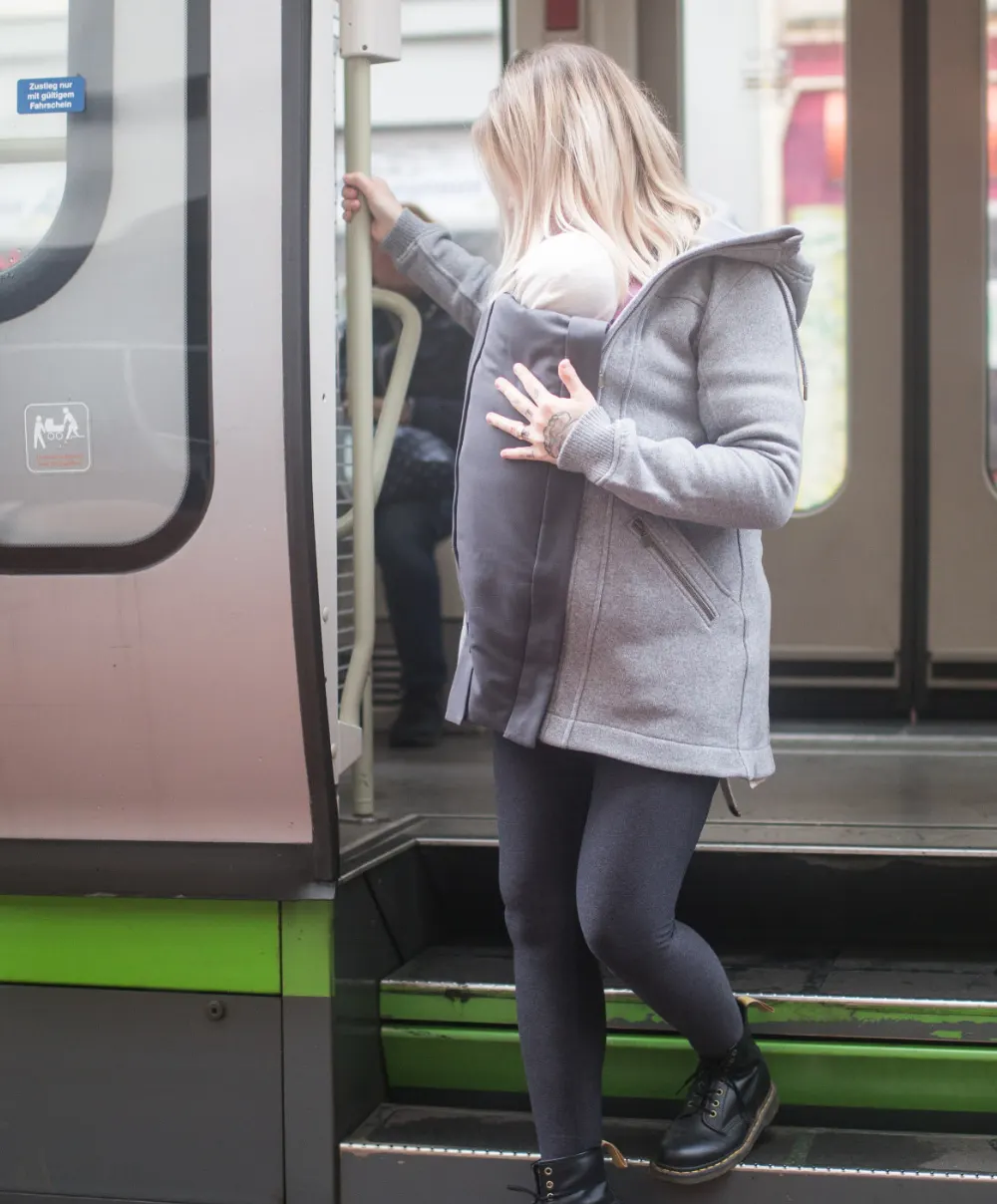 Frau steigt mit Baby in der Kumja in die Bahn
